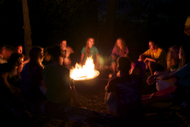 Wheaton Passage students around a campfire.