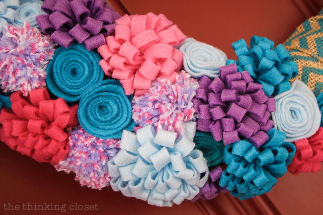 A bevy of beautiful felt flowers and pom poms really jazz up a spring to summer wreath! via thinkingcloset.com A bevy of beautiful felt flowers and pom poms really jazz up a spring to summer wreath! via thinkingcloset.com