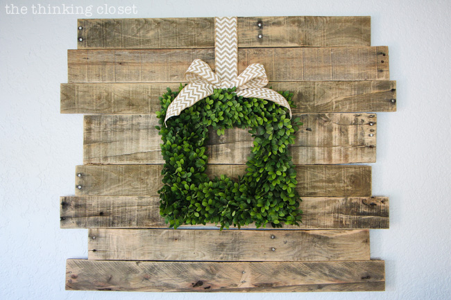 Rustic Vintage Spring Mantel: a pallet sign is the lovely backdrop for a boxwood wreath!  via thinkingcloset.com