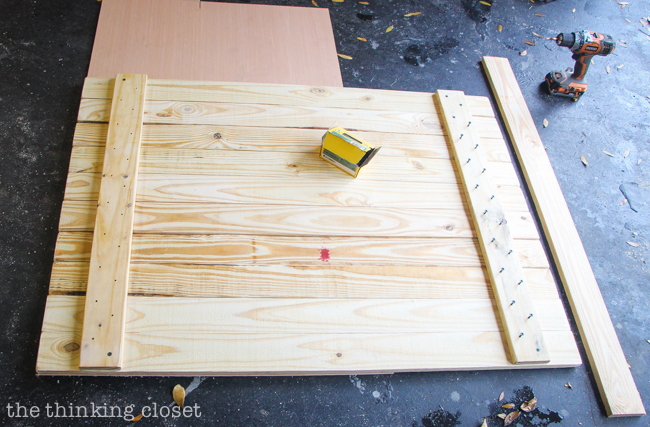 DIY Coastal Wood Plank Photo Backdrop  |  Screwing in the connector pieces to assemble the pallet.