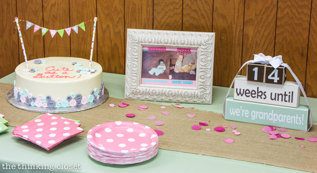 "Cute as a Button" Baby Shower | DIY & Handmade Baby Shower Ideas to Inspire a Party to Remember! The cake table, complete with button cake, baby photos of the parents-to-be, and countdown blocks!