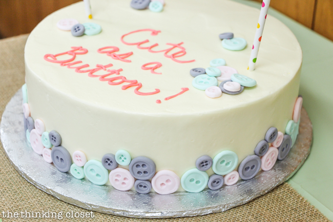 "Cute as a Button" Baby Shower | DIY & Handmade Baby Shower Ideas to Inspire a Party to Remember! Cake topper with mini banner was easy to DIY and the fondant button cake was created by a local bakery! Yum.