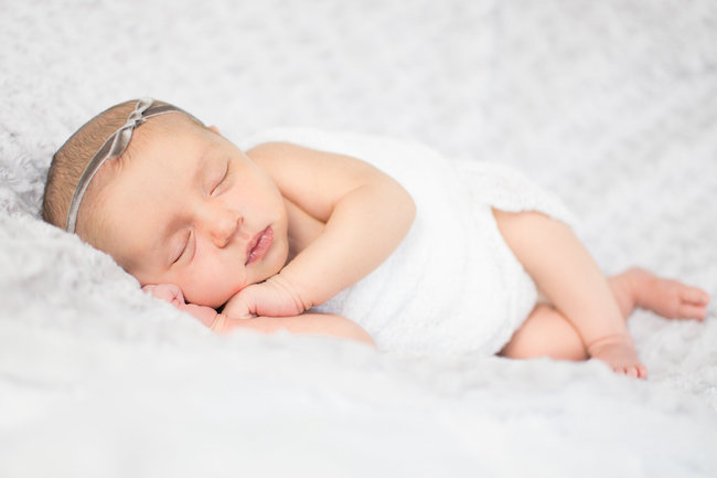 Juniper's 2 week newborn photography shoot: adorable hair bows, muslin swaddles, and a sweet smiling baby in a bucket. Brace yourself for the cuteness!
