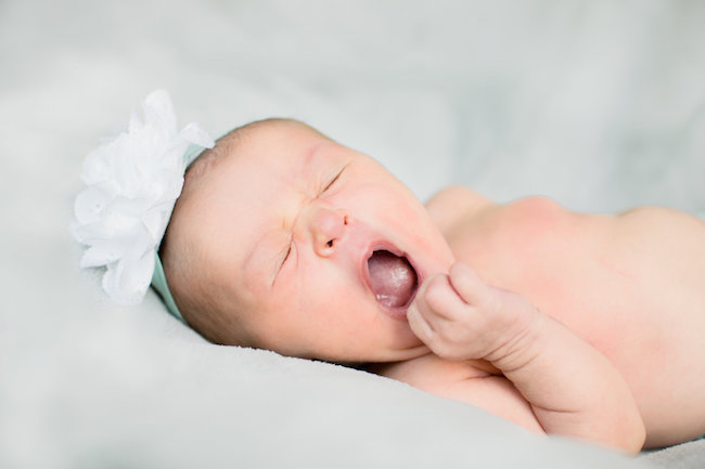 Juniper's 2 week newborn photography shoot: adorable hair bows, muslin swaddles, and a sweet smiling baby in a bucket. Brace yourself for the cuteness!