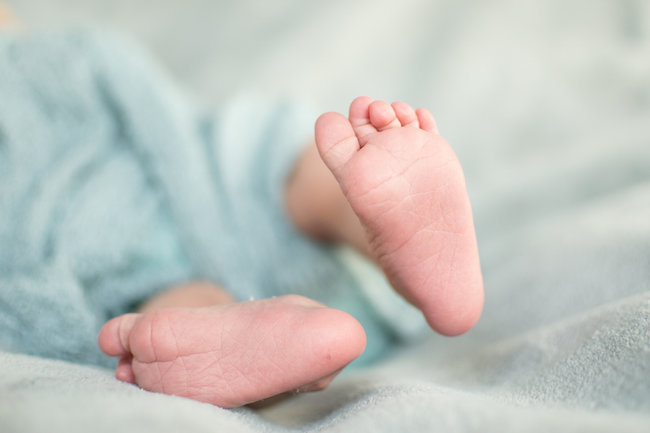 Juniper's 2 week newborn photography shoot: adorable hair bows, muslin swaddles, and a sweet smiling baby in a bucket. Brace yourself for the cuteness!