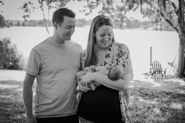 Juniper's 2 week newborn photography shoot: adorable hair bows, muslin swaddles, and a sweet smiling baby in a bucket. Brace yourself for the cuteness!