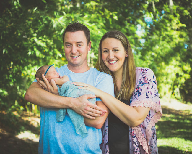 Juniper's 2 week newborn photography shoot: adorable hair bows, muslin swaddles, and a sweet smiling baby in a bucket. Brace yourself for the cuteness!