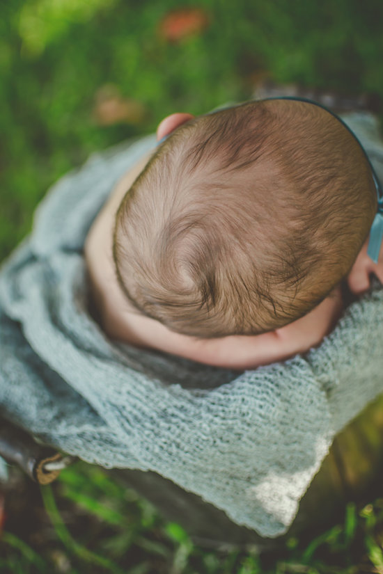 Juniper's 2 week newborn photography shoot: adorable hair bows, muslin swaddles, and a sweet smiling baby in a bucket. Brace yourself for the cuteness!