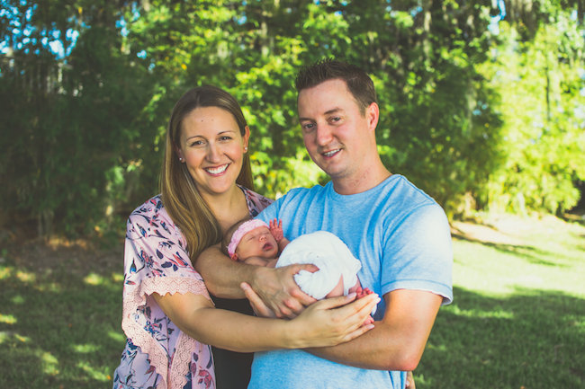 Juniper's 2 week newborn photography shoot: adorable hair bows, muslin swaddles, and a sweet smiling baby in a bucket. Brace yourself for the cuteness!