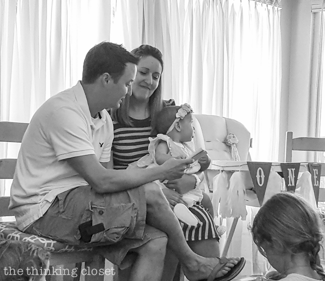 Reading aloud letters to the birthday girl at her Blooming First Birthday Bash, inspired by spring flowers in pink, blush, and white. DIY party ideas for a woodland floral-themed celebration, spring fling, or botanical garden party!