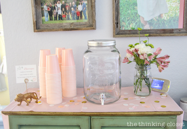 Raspberry lemonade, mini sign holders, and fresh flowers on display at a Blooming First Birthday Bash, inspired by spring flowers in pink, blush, and white. DIY party ideas for a woodland floral-themed celebration, spring fling, or botanical garden party!