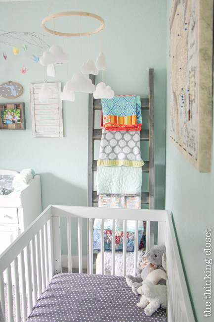 "Little Adventurer" Nursery Tour | An inspirational space with vintage-modern furniture, travel-themed decor, and a gender-neutral color palette of mint, gray, and white. Lovin' this blanket letter as a practical way to store blankets and encourage their use while beautifying the space with their fun patterns!