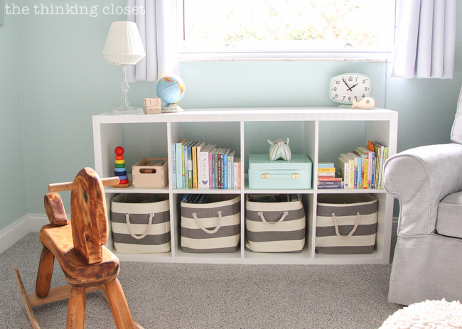 "Little Adventurer" Nursery Tour | An inspirational space with vintage-modern furniture, travel-themed decor, and a gender-neutral color palette of mint, gray, and white. Gotta love a bookshelf that has spots for books you're currently reading, books for when baby is a bit older (in the bins), and extra space to display favorite toys!