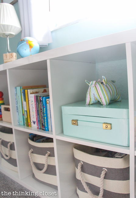 "Little Adventurer" Nursery Tour | An inspirational space with vintage-modern furniture, travel-themed decor, and a gender-neutral color palette of mint, gray, and white. Gotta love a bookshelf that has spots for books you're currently reading, books for when baby is a bit older (in the bins), and extra space to display favorite toys!