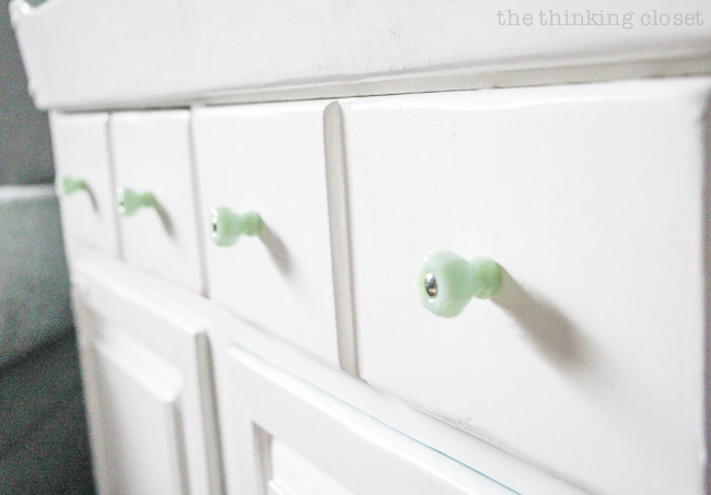 "Little Adventurer" Nursery Tour | An inspirational space with vintage-modern furniture, travel-themed decor, and a gender-neutral color palette of mint, gray, and white. I love this dry sink turned into diaper changing station...and the antique milk-green jadeite knobs from D. Lawless really add to the vintage vibe!
