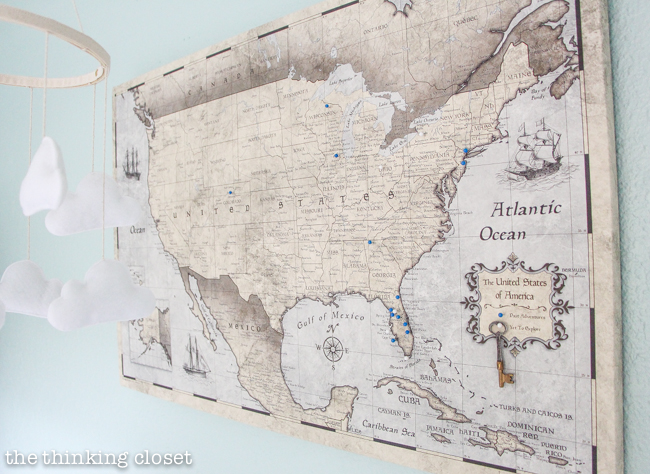 "Little Adventurer" Nursery Tour | An inspirational space with vintage-modern furniture, travel-themed decor, and a gender-neutral color palette of mint, gray, and white. Lovin' this travel map with blue pins to mark past adventures...and white pins to mark places yet to be explored....