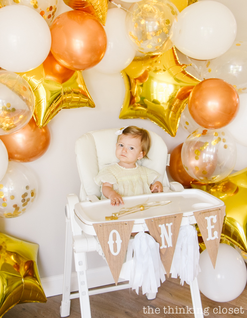 How to make your own balloon garland party backdrop and pennant ONE high chair banner! Check out my post for tips and tricks. | A "Twinkle Twinkle Little Star" 1st Birthday Party, inspired by our favorite baby lullaby. DIY party ideas for a dazzling celebration for your shining star's first birthday or baby shower! via thinkingcloset.com