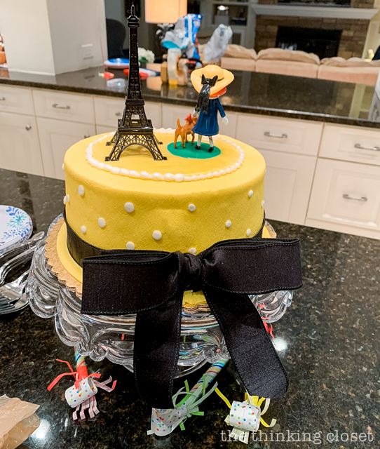 Check out our Madeline-themed birthday cake, decorated to look like Madeline's yellow hat with a satin black ribbon tied around it. Très chic! | How to host a "Madeline In Paris"-themed 4th birthday party at home with creative DIY party activities, French decor, and costumes inspired by the classic Madeline children's books via ThinkingCloset.com