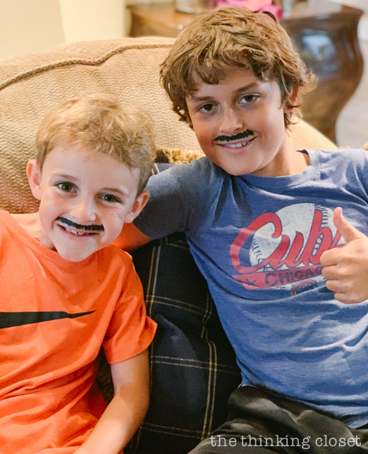 Party guests received Parisian accessories upon arrival. the boys got French mustaches drawn on with eyeliner! | How to host a "Madeline In Paris"-themed 4th birthday party at home with creative DIY party activities, French decor, and costumes inspired by the classic Madeline children's books via ThinkingCloset.com