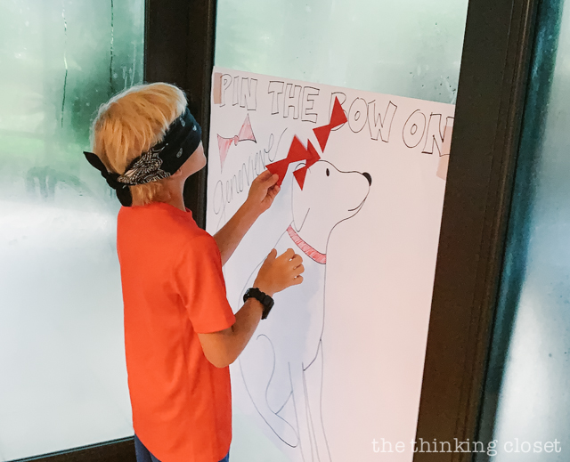 One of our party games was a variation of "pin the tail on the donkey"... this one was "pin the bow on Genevieve," Madeline's dog who rescues her! | How to host a "Madeline In Paris"-themed 4th birthday party at home with creative DIY party activities, French decor, and costumes inspired by the classic Madeline children's books via ThinkingCloset.com