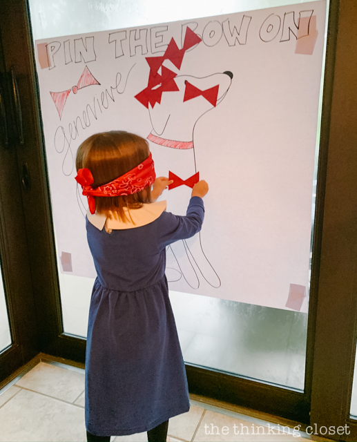 One of our party games was a variation of "pin the tail on the donkey"... this one was "pin the bow on Genevieve," Madeline's dog who rescues her! | How to host a "Madeline In Paris"-themed 4th birthday party at home with creative DIY party activities, French decor, and costumes inspired by the classic Madeline children's books via ThinkingCloset.com