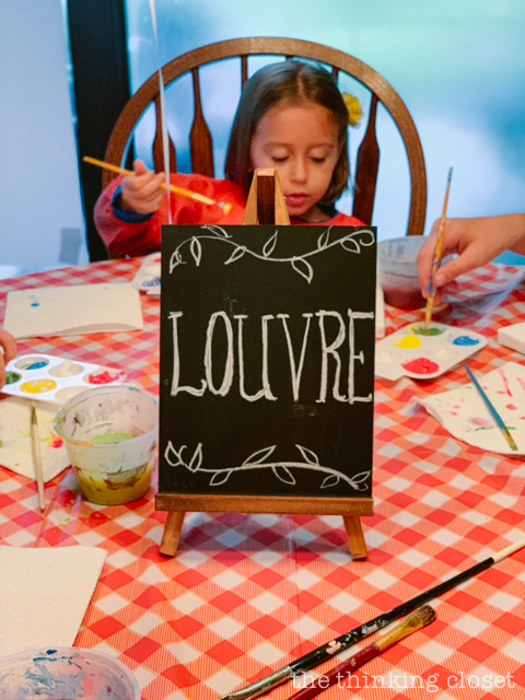 Each party guest got to paint their own art canvas at The Louvre. Each canvas featured a classic scene from Madeline (pre-selected by the kids), and they each got to take home their masterpiece as a party favor! | How to host a "Madeline In Paris"-themed 4th birthday party at home with creative DIY party activities, French decor, and costumes inspired by the classic Madeline children's books via ThinkingCloset.com