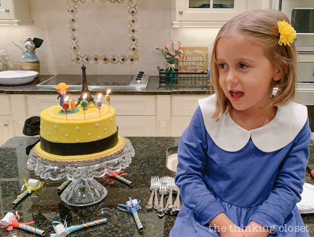 Check out our Madeline-themed birthday cake, decorated to look like Madeline's yellow hat with a satin black ribbon tied around it. Très chic! | How to host a "Madeline In Paris"-themed 4th birthday party at home with creative DIY party activities, French decor, and costumes inspired by the classic Madeline children's books via ThinkingCloset.com