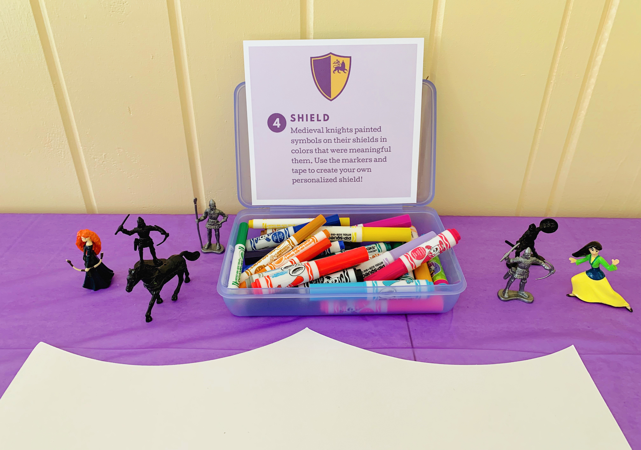 Shield decorating station at Juniper's "Princesses & Knights" 5th Birthday Pool Party & Royal Golden Birthday Celebration | Creative ideas including a punny invitation, DIY castle backdrop, a golden birthday banner, creative activities for kids of all ages & party favors galore! via thinkingcloset.com