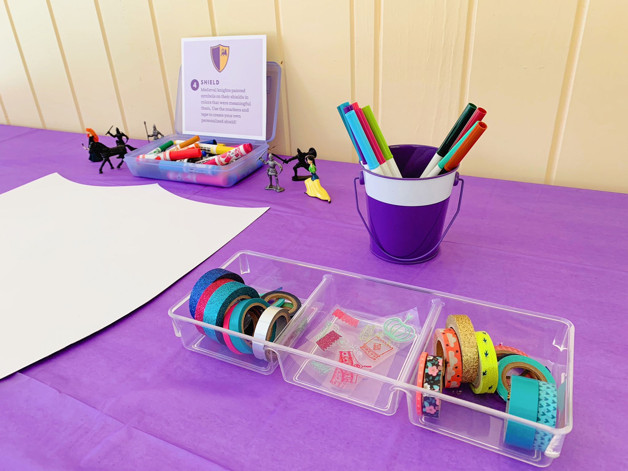 Shield decorating station at Juniper's "Princesses & Knights" 5th Birthday Pool Party & Royal Golden Birthday Celebration | Creative ideas including a punny invitation, DIY castle backdrop, a golden birthday banner, creative activities for kids of all ages & party favors galore! via thinkingcloset.com
