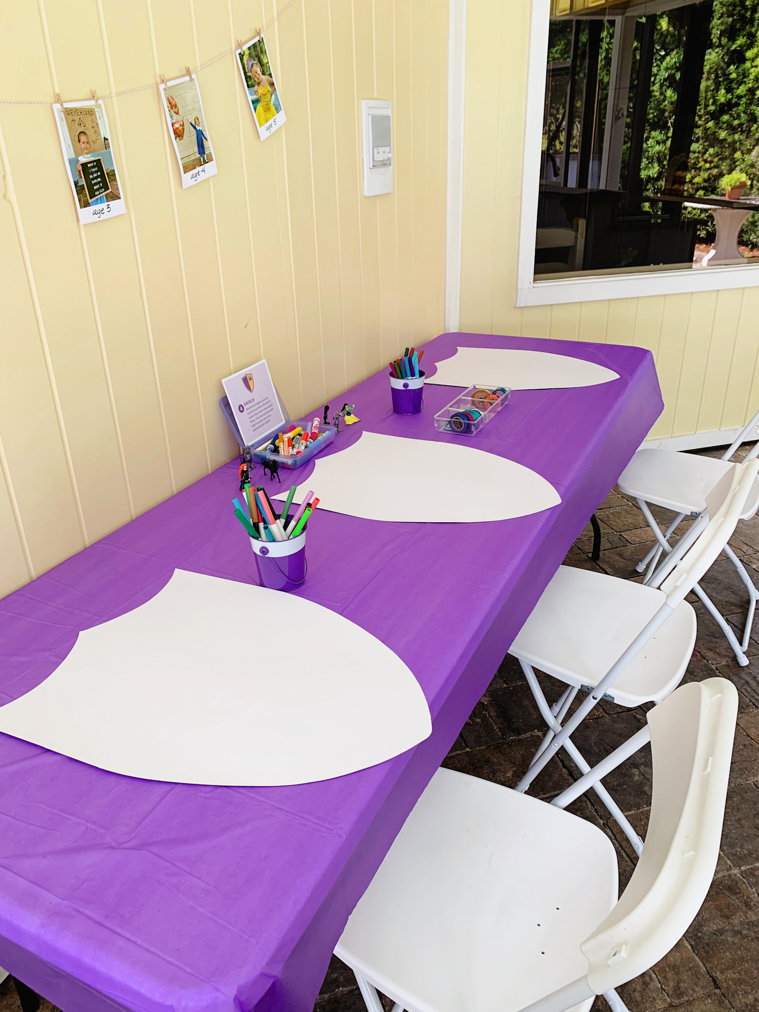 Shield decorating station at Juniper's "Princesses & Knights" 5th Birthday Pool Party & Royal Golden Birthday Celebration | Creative ideas including a punny invitation, DIY castle backdrop, a golden birthday banner, creative activities for kids of all ages & party favors galore! via thinkingcloset.com